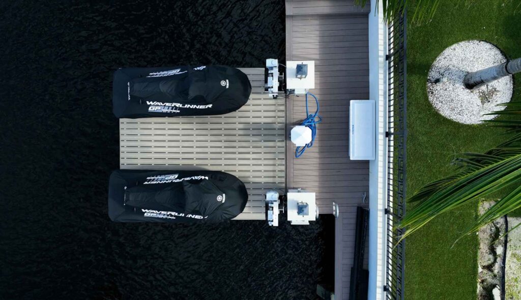 Top-down view of two black jet skis on a dual jet ski platform lift.