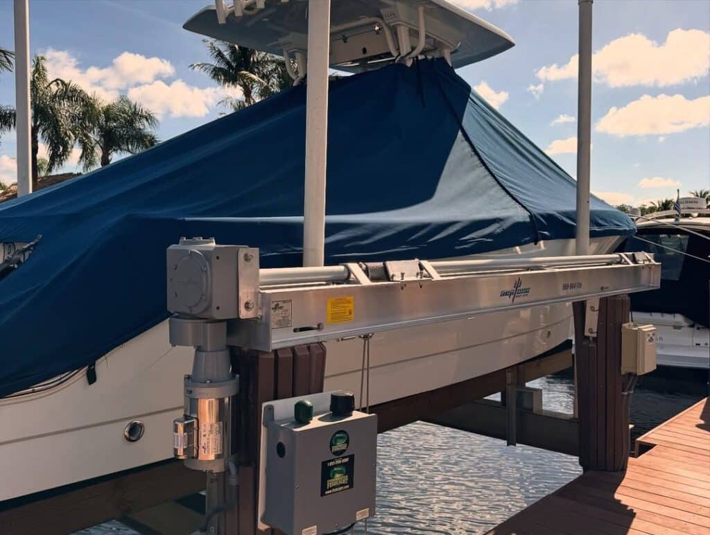 Close-up of a 4-post boat lift motor and drive with a covered center console behind it in Pompano Beach.