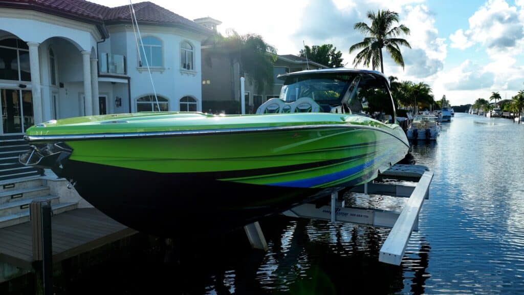 Green and blue performance boat raised on an elevator boat lift.