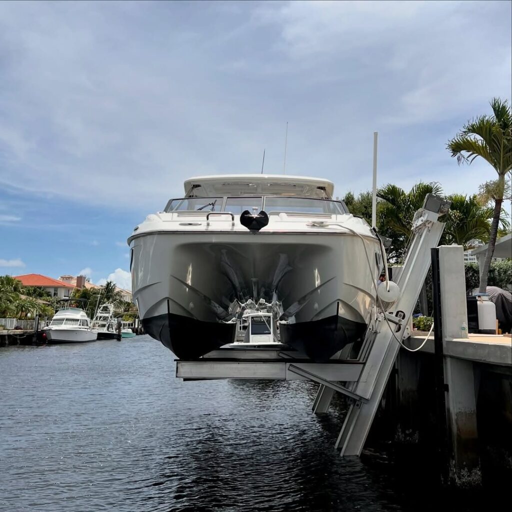 Head-on view of a white power catamaran raised on an elevator boat lift.